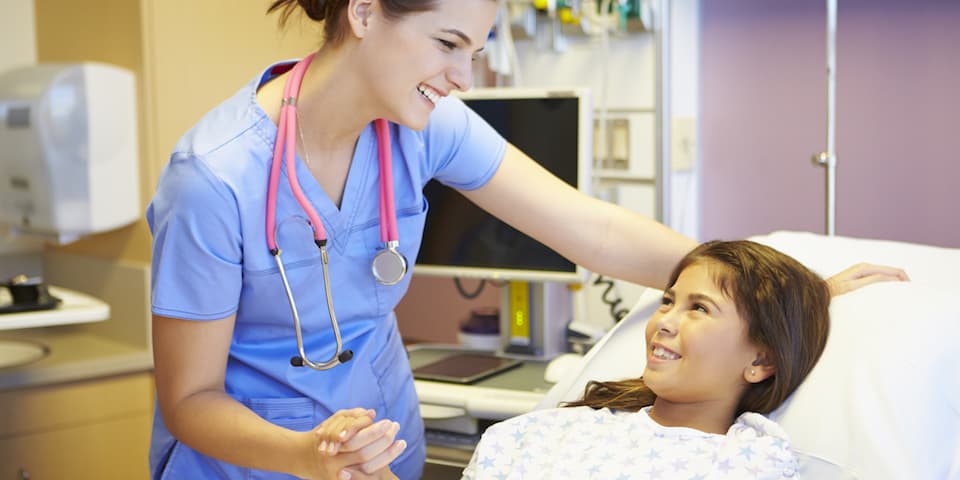 smiling-nurse-with-child-patient-in-hospital-room
