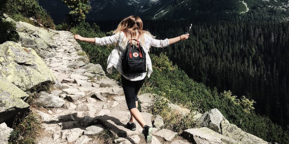 young-woman-with-backpack-hiking-on-mountain