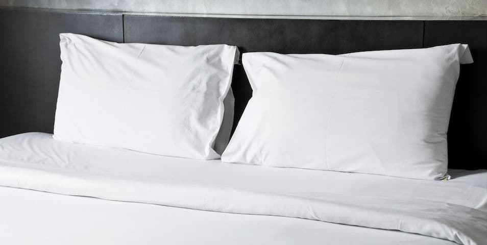 bed-made-with-white-sheets-and-pillows